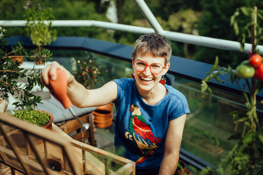 Primoa-Balkon-mit-Tomaten-Manuela-Baron-beim-Auspflanzen-und-Gießen-am-Stadtbalkon
