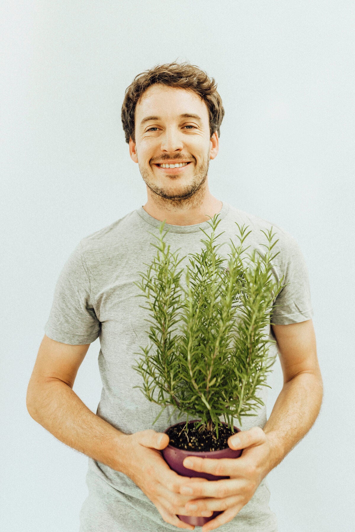 Sebastian mit einer Pflanze in den Händen