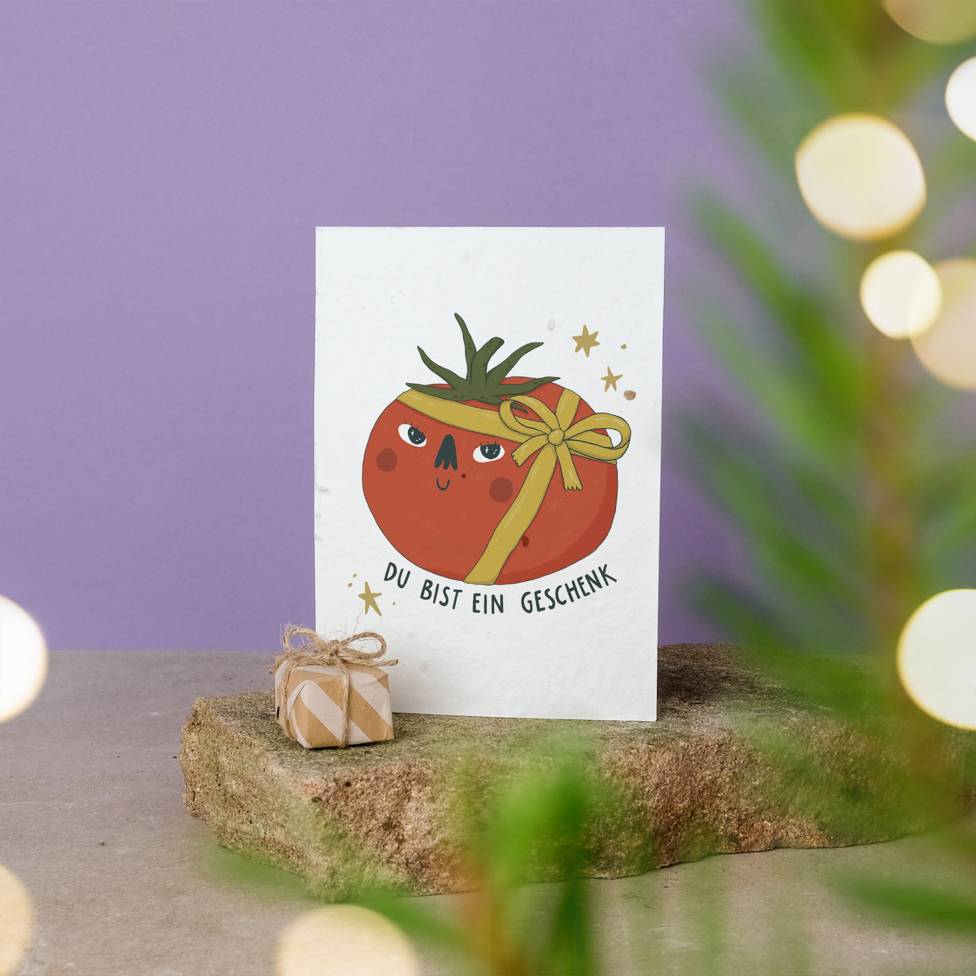 Postkartenmotiv mit als Geschenk eingepackter Tomate